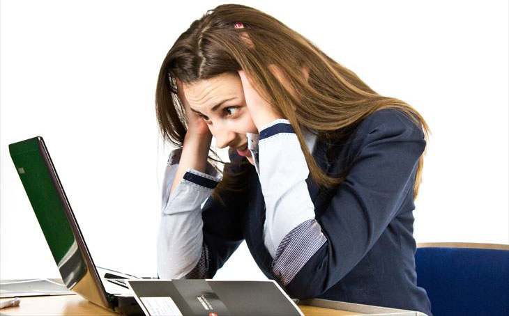 パソコンの前で頭をかかえる女性